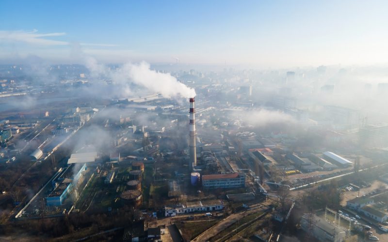 Aerial drone view of Chisinau. Thermal station with smoke coming out of the tube. Buildings and roads. Fog in the air. Moldova
